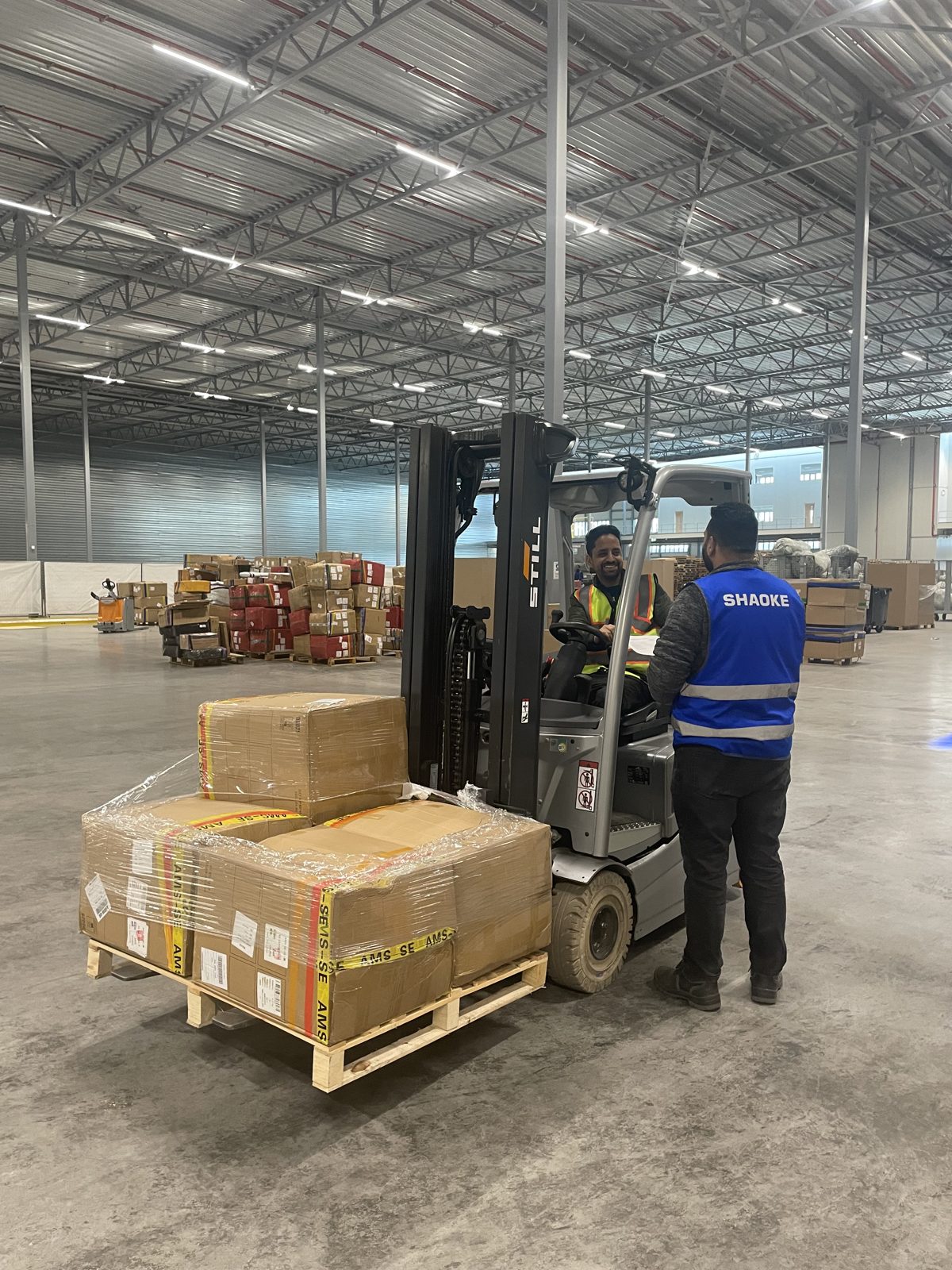Heftruckchauffeur van Work Supply in overleg met een teamleider van Shaoke op de werkvloer